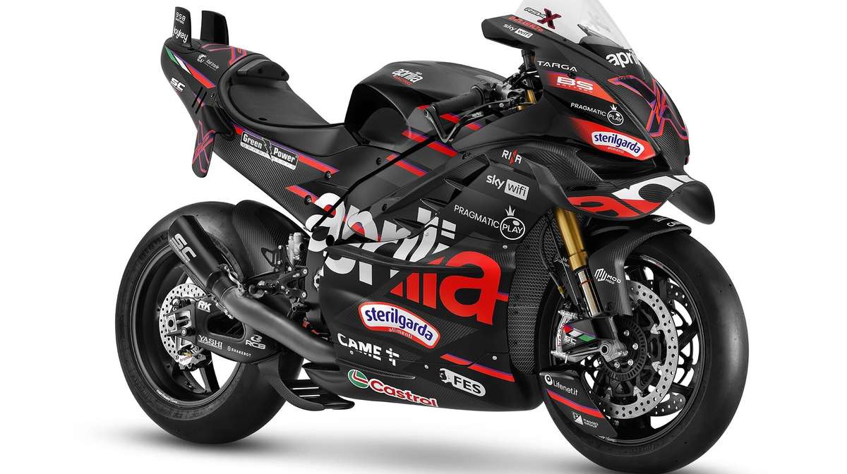 Aprilia RS-GP accelerating off the grid at race start with rider crouched behind the windscreen