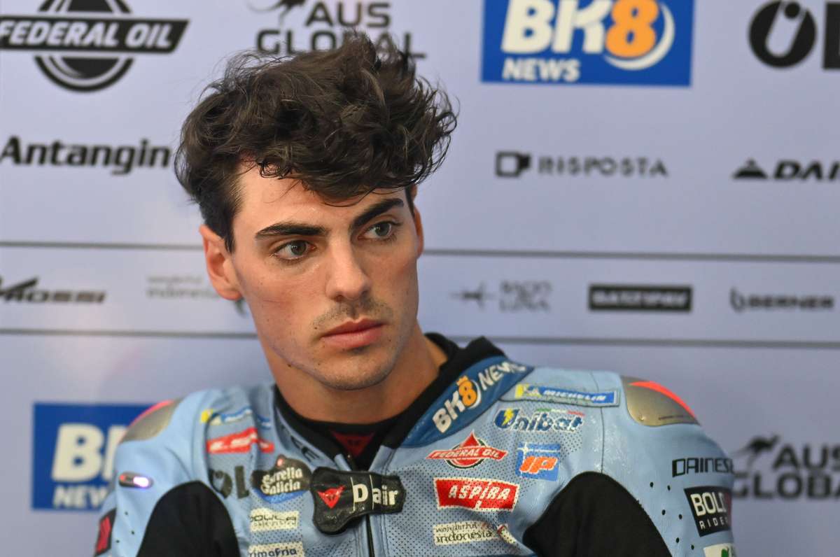 Fermín Aldeguer celebrating on the podium after a FIM CEV race victory with team and trophy