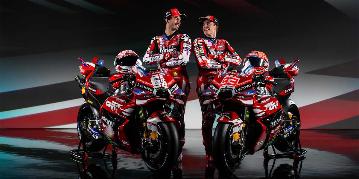 Ducati Corse factory garage with mechanics working on a MotoGP bike under bright lights