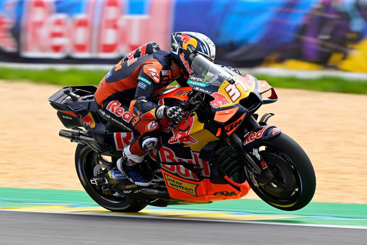 KTM MotoGP prototype undergoing testing with engineers observing data at the circuit pit lane