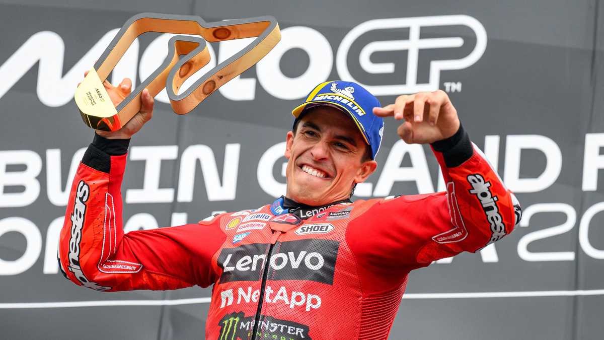 Profile view of Marc Márquez wearing a full-face racing helmet with sponsor decals