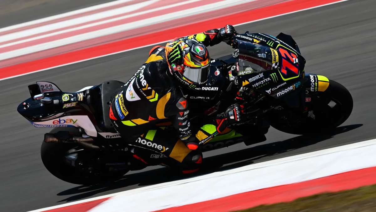 Marco Bezzecchi leaning into a heavy braking zone, front wheel compressed and rear wheel lifting slightly as he prepares to…