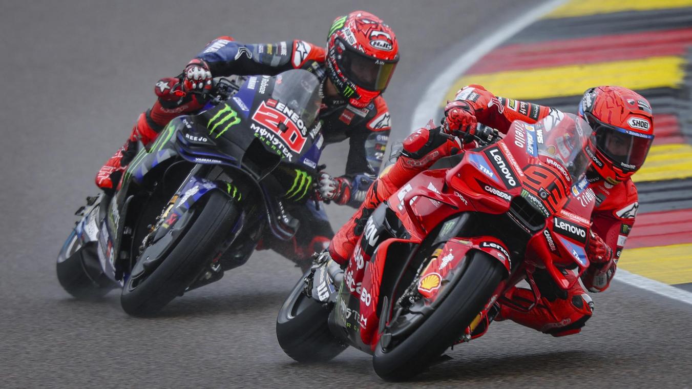 Marc Márquez leaning hard and braking late into a corner at Balaton Park, front wheel slightly compressed and sparks visible