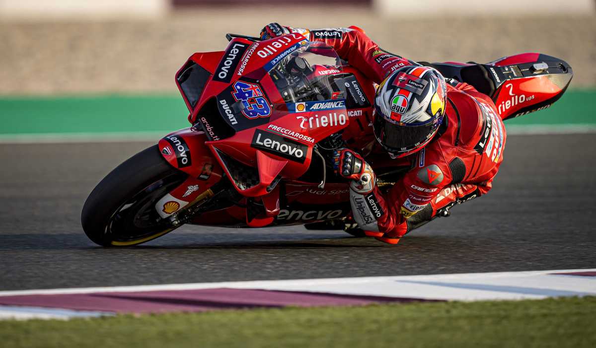 Jack Miller standing the bike up with a late hard braking approach into a corner, front suspension compressed and wheel…