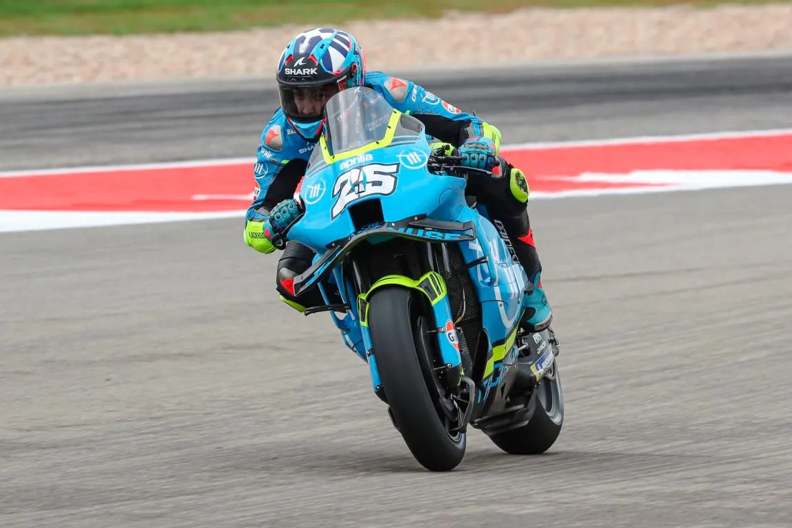 Raúl Fernández celebrating his first MotoGP victory at Phillip Island with arms raised on the podium