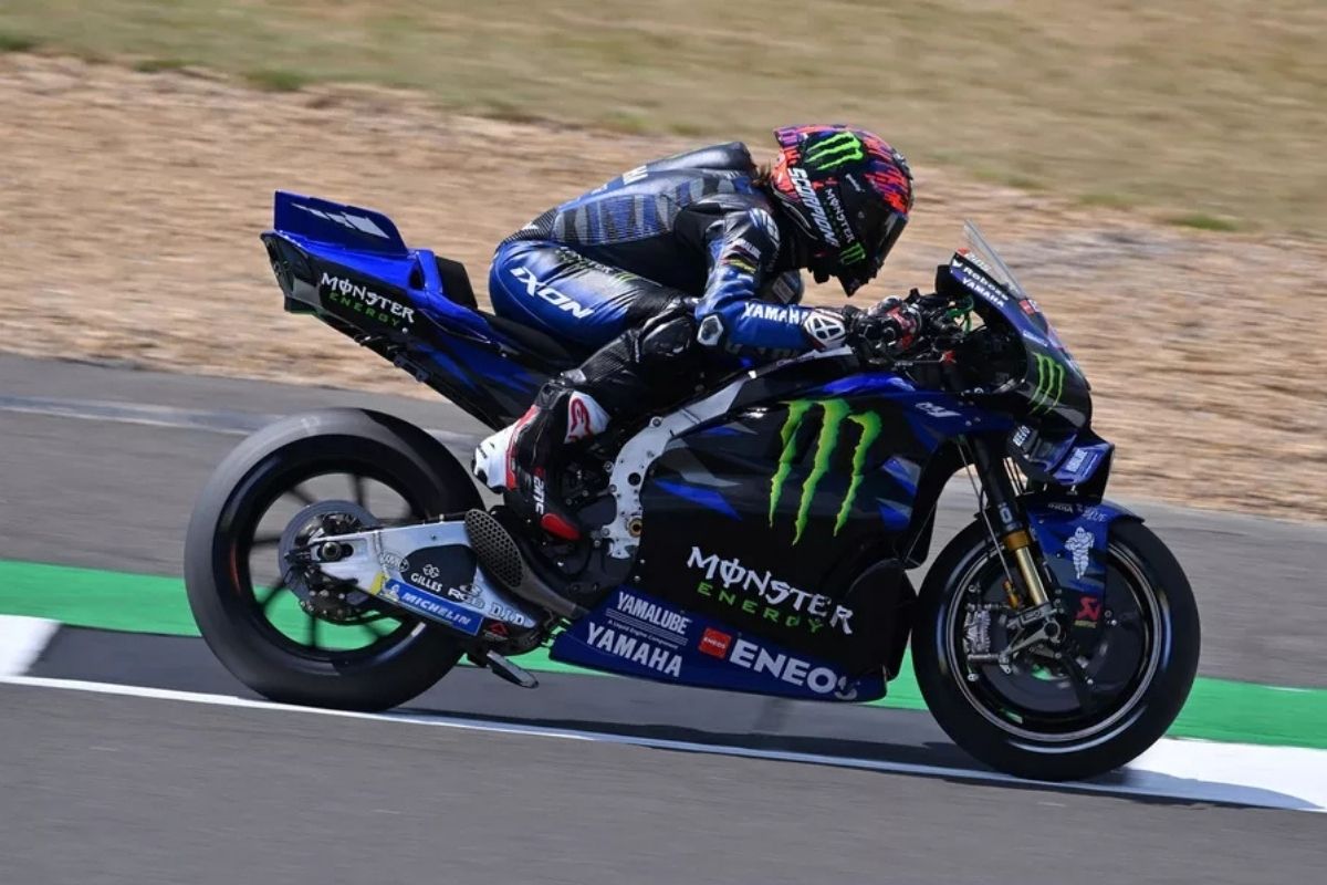 Yamaha YZR-M1 leaned over through a fast Jerez corner with the rider holding a smooth MotoGP line near the red and white curbs.