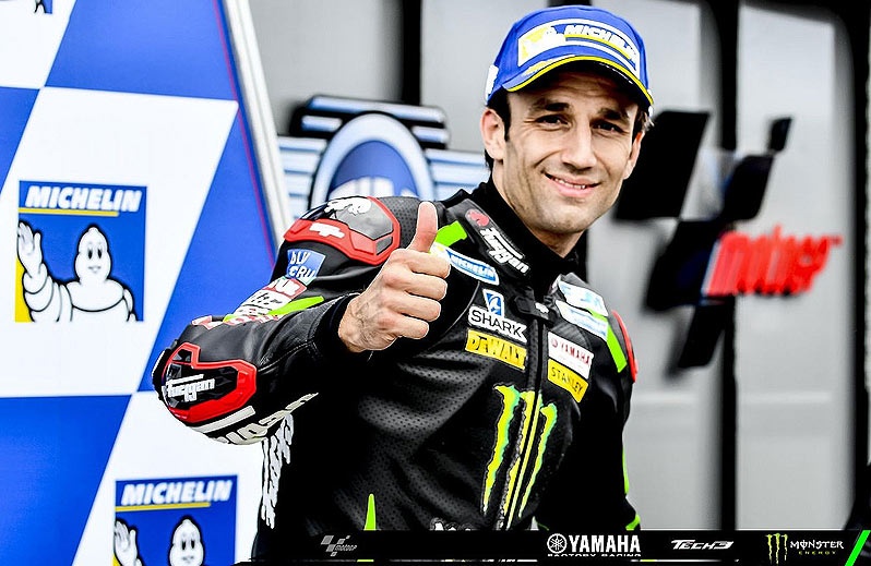 Johann Zarco on his Honda tracing a precise wet racing line at Brno, water spray visible behind the rear wheel